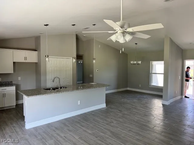 a kitchen with kitchen island a counter top space appliances and a ceiling fan
