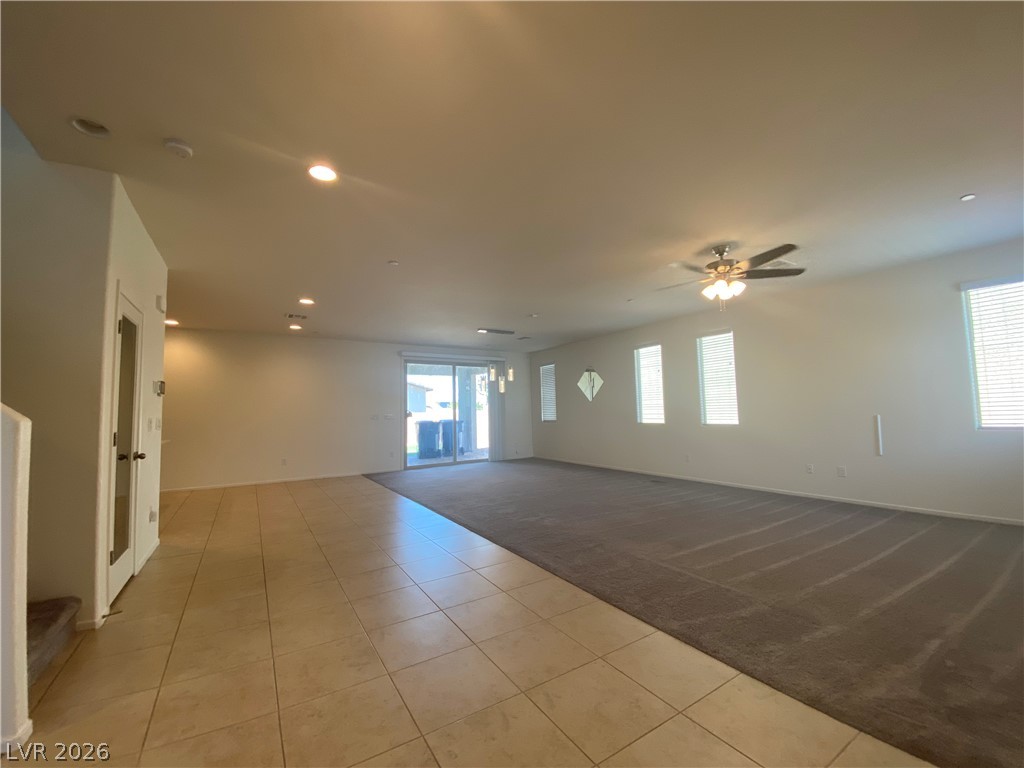 436 Cadence View Way Henderson, NV 89011 - Photo 5 of 36 A spacious living area combines tiled and carpeted flooring, bathed in natural light from multiple windows.