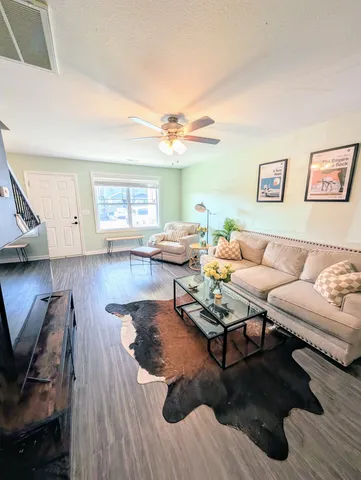 a living room with furniture and a wooden floor