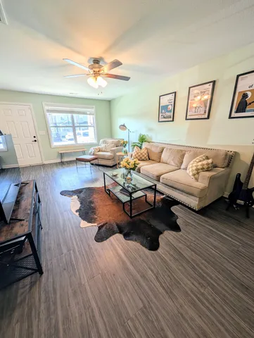 a living room with furniture and wooden floor