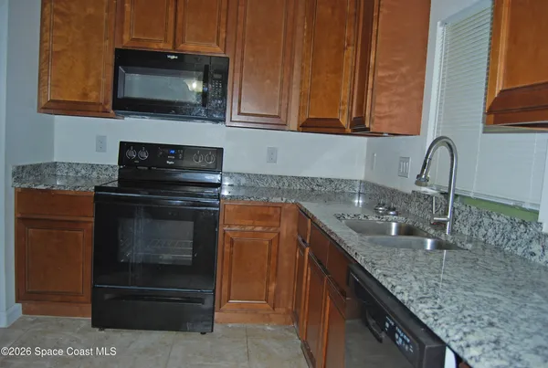 a kitchen with granite countertop a sink and a stove