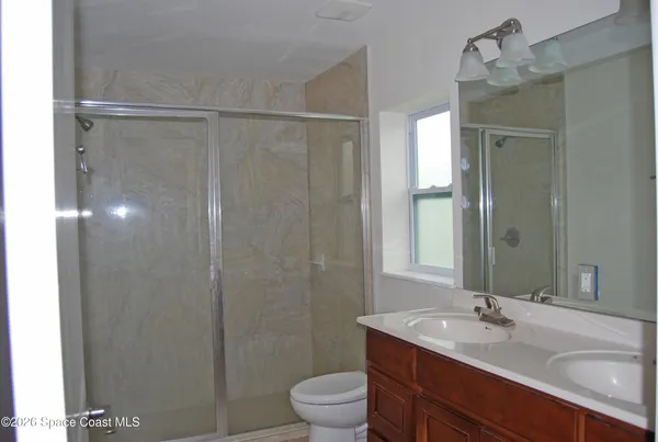 a bathroom with a granite countertop sink toilet a large mirror and shower