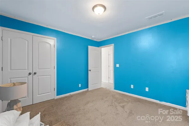 a bedroom with a bed chandelier and a window