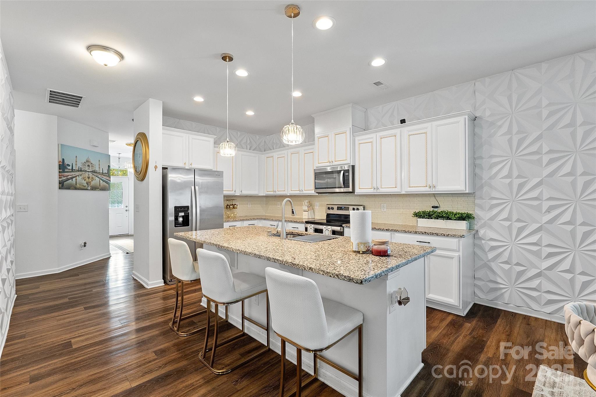 14027 Ridgewater Way Charlotte, NC 28278 - Photo 28 of 48 a kitchen with stainless steel appliances granite countertop a refrigerator a stove microwave and white cabinets with wooden floor