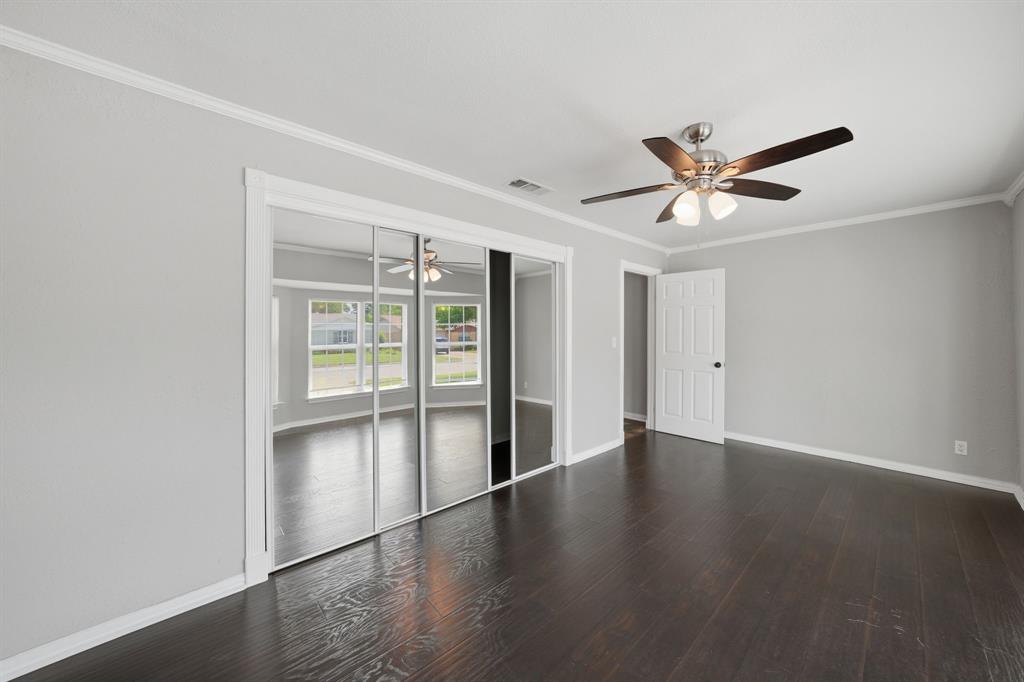 1108 Billie Ruth Lane Hurst, TX 76053 - Photo 10 of 27 Spacious room featuring dark wood-finish flooring, light grey walls, and white crown molding