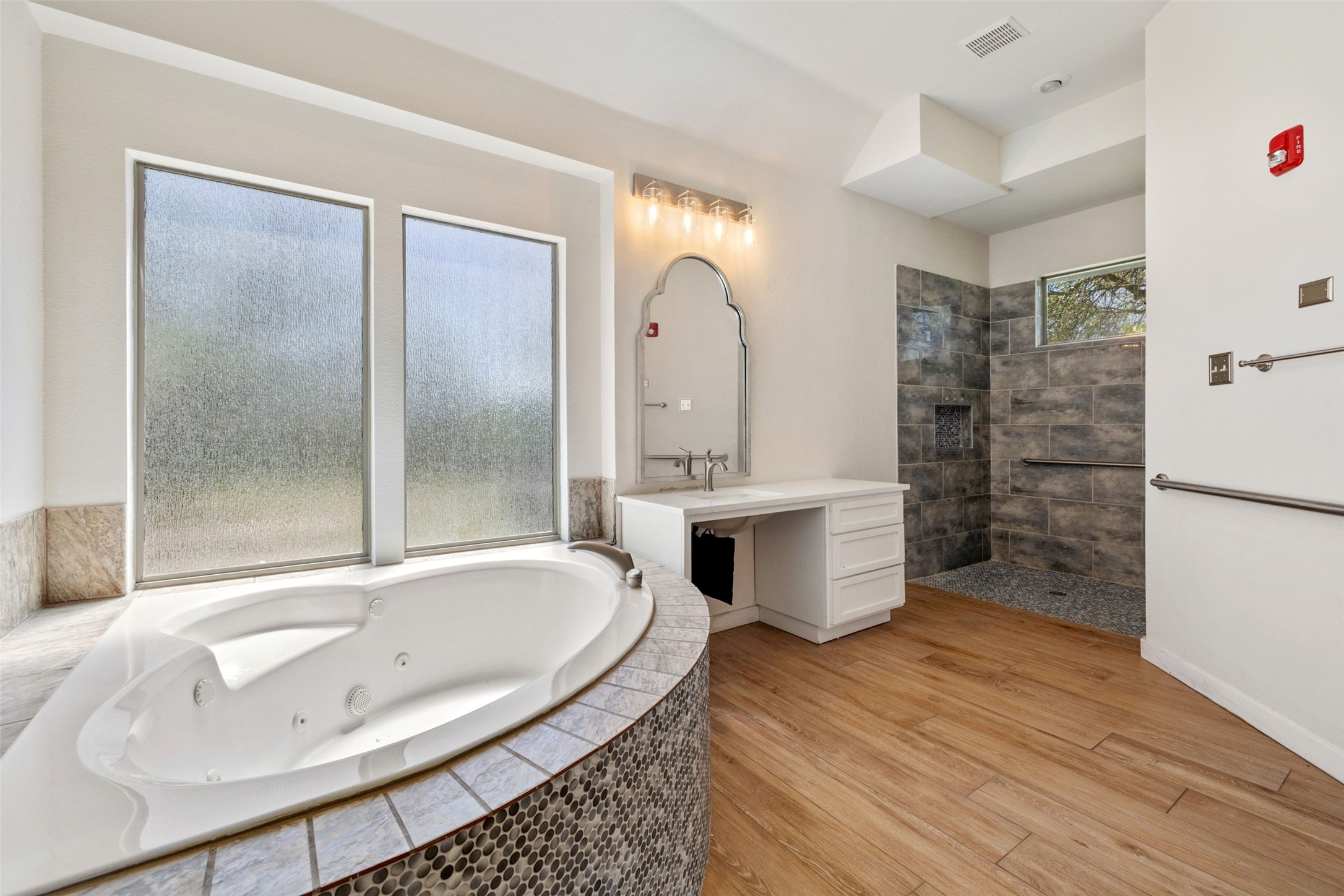 815 Elliott Ranch Road Buda, TX 78610 - Photo 13 of 40 Bathroom with walk in shower, vanity, light wood-type flooring, and a whirlpool tub