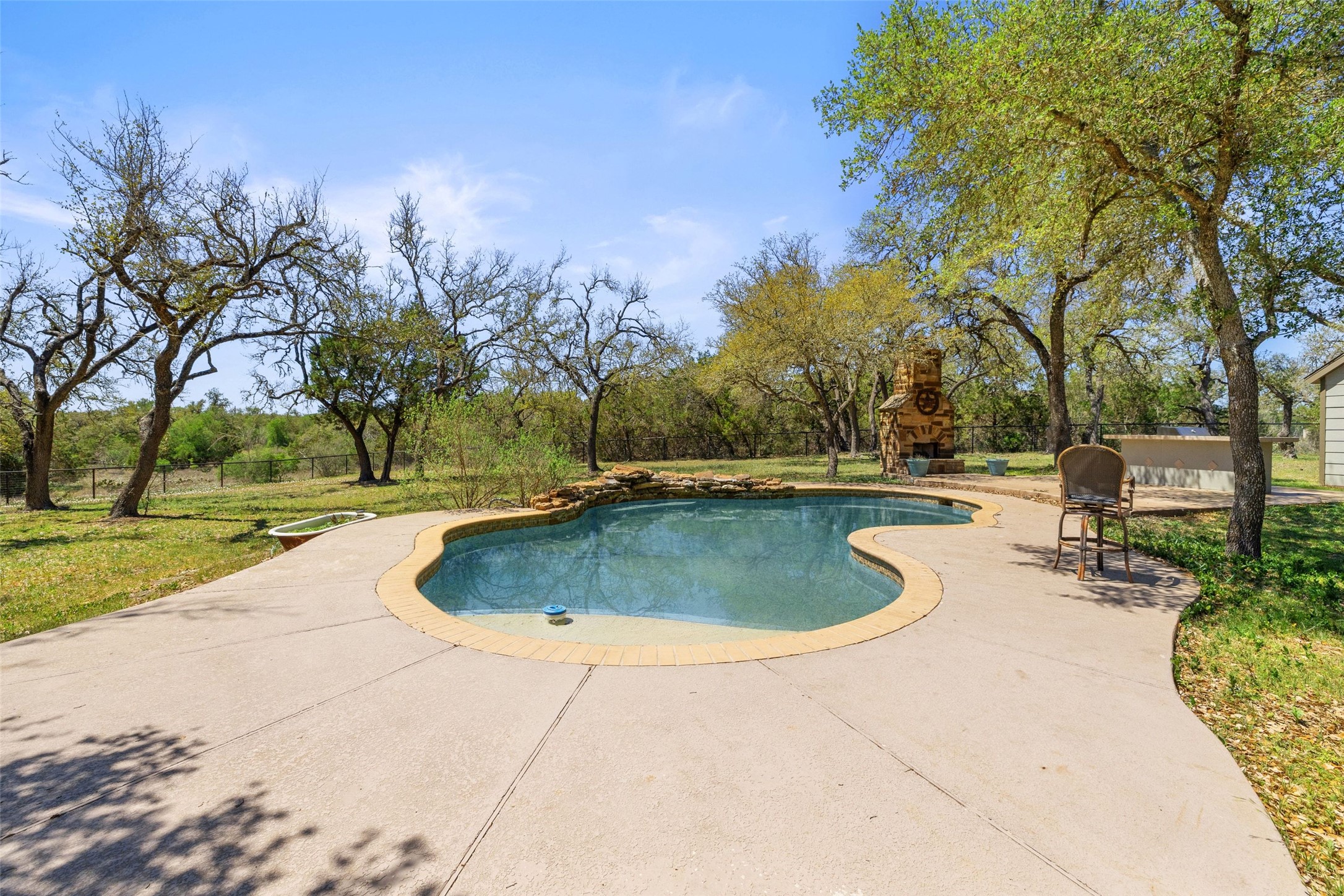 815 Elliott Ranch Road Buda, TX 78610 - Photo 23 of 40 Outdoor pool with a patio and a fireplace