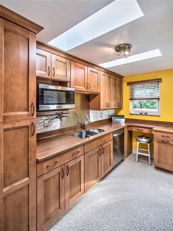 9101 Pannier Road Pittsburgh, PA 15237 - Photo 14 of 24 Eat-in Kitchen beautifully renovated with 2 Skylights, Maple Cabinetry, Under Cabinet Lighting, Corian Countertops, sleek new Flooring, Tile Backsplash, Electric Range, Refrigerator, Dishwasher & Microwave Oven