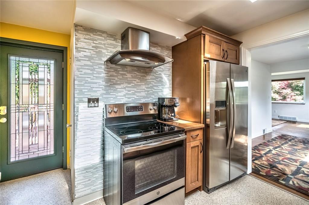 9101 Pannier Road Pittsburgh, PA 15237 - Photo 16 of 24 Eat-in Kitchen beautifully renovated with 2 Skylights, Maple Cabinetry, Under Cabinet Lighting, Corian Countertops, sleek new Flooring, Tile Backsplash, Electric Range, Refrigerator, Dishwasher & Microwave Oven