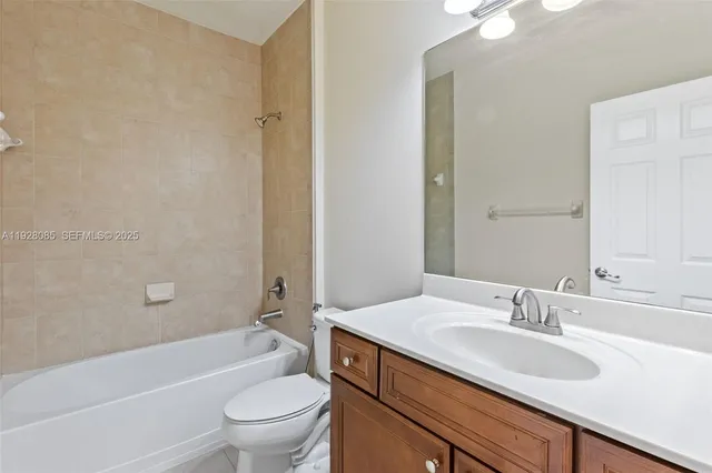 a bathroom with a granite countertop sink a toilet and shower