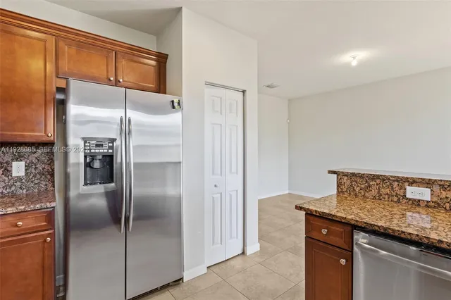 a kitchen with stainless steel appliances granite countertop a refrigerator and a sink