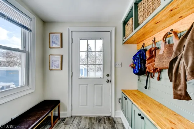 a hallway with a large window and a potted plant on the wall