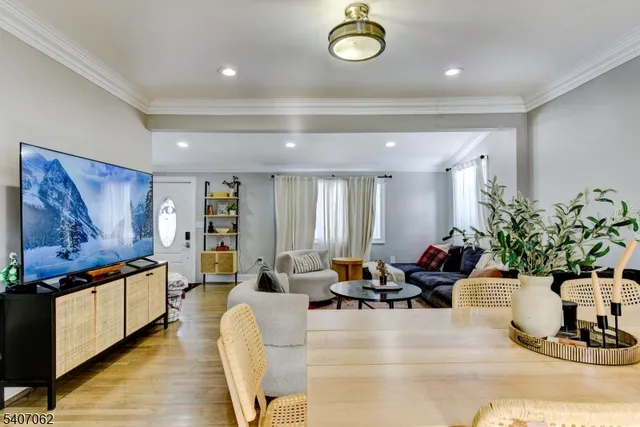 a living room with furniture potted plant and kitchen view
