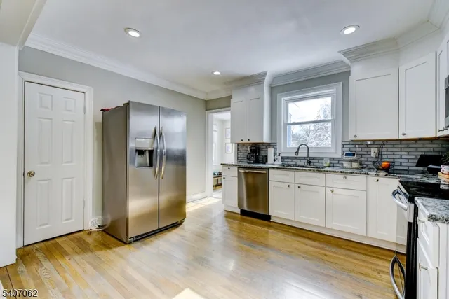 a kitchen with granite countertop a refrigerator and a stove top oven