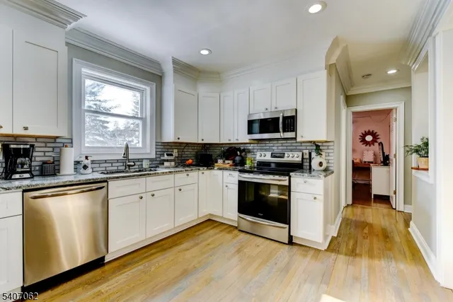 a kitchen with granite countertop a stove top oven a sink a counter space and cabinets