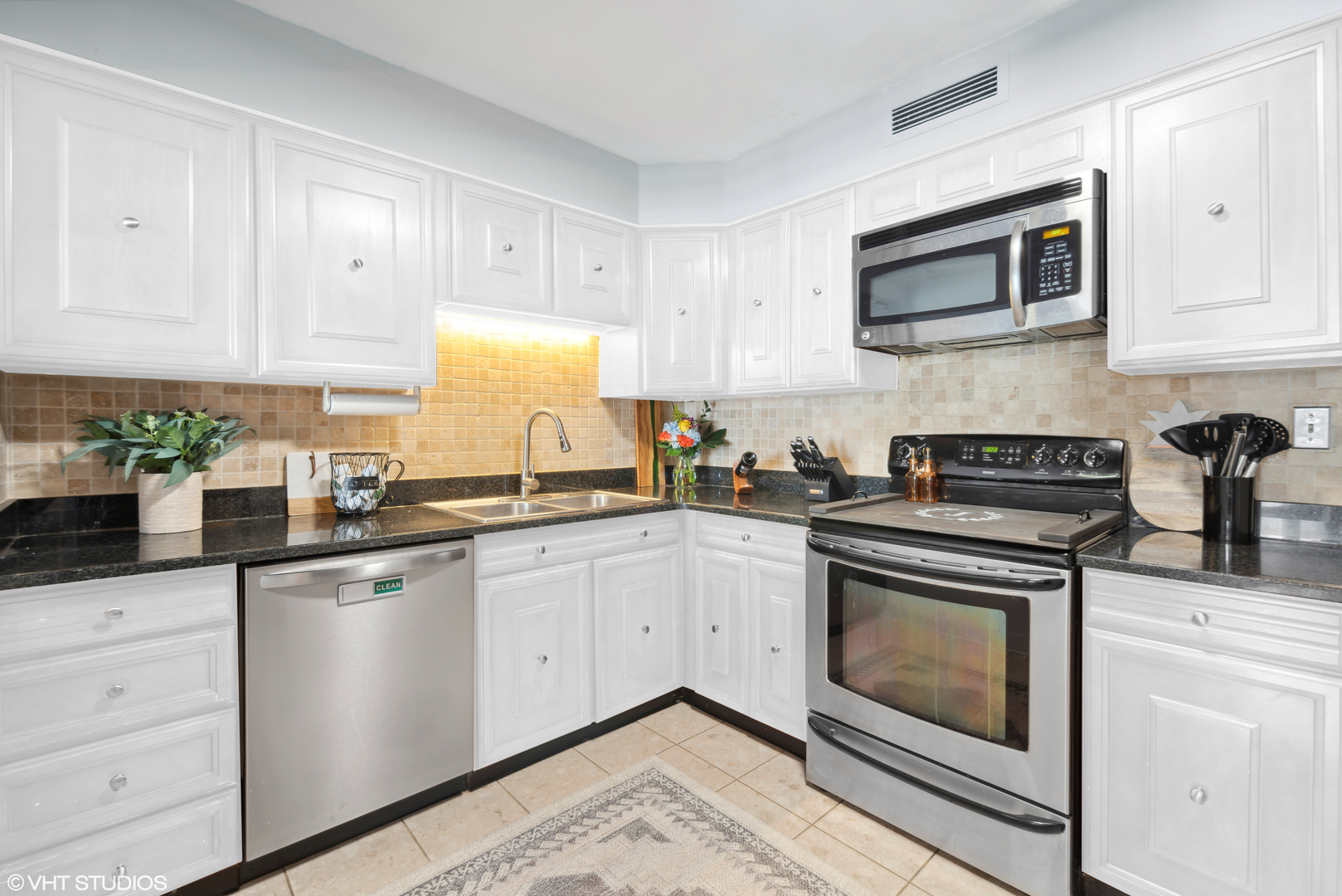 6007 North Sheridan Road, Unit 31F Chicago, IL 60660 - Photo 7 of 43 a kitchen with granite countertop white cabinets stainless steel appliances and sink