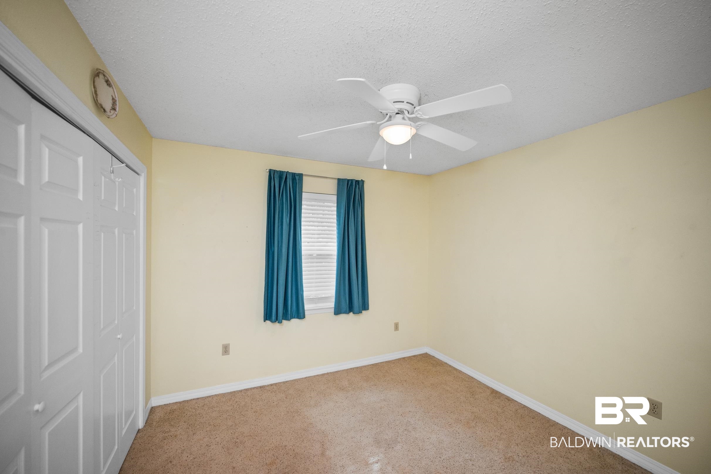 123 Dunbar Loop Daphne, AL 36526 - Photo 19 of 33 Unfurnished bedroom with a closet, a textured ceiling, a ceiling fan, and carpet floors