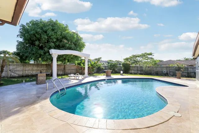 a view of a house with backyard and sitting area
