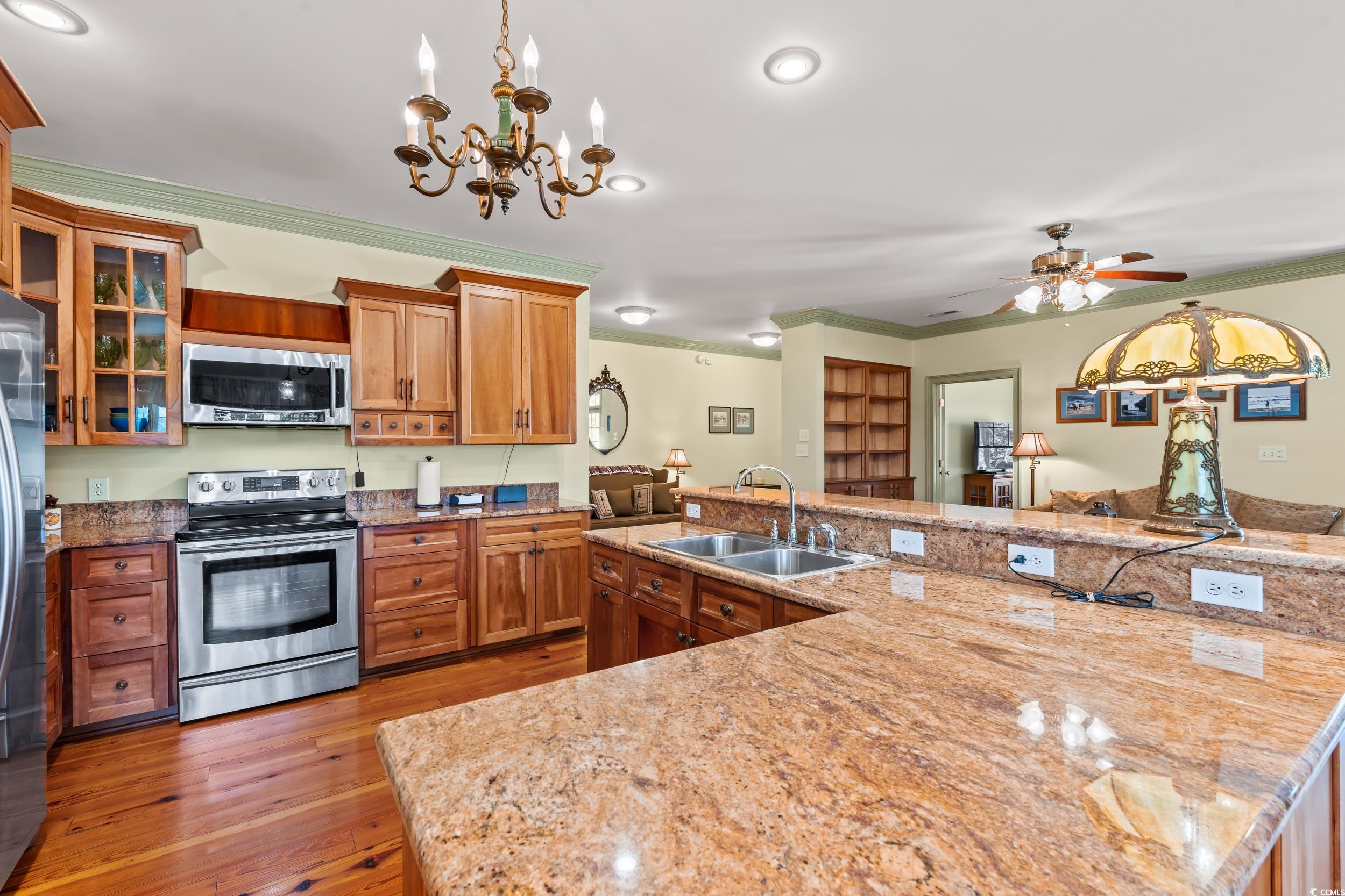 246 County Rd S-22-656 Murrells Inlet, SC 29576 - Photo 9 of 39 Kitchen featuring crown molding, brown cabinets, a