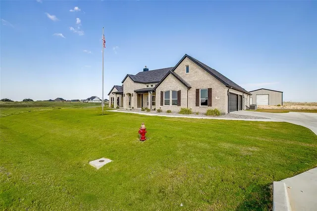 a front view of a house with a big yard