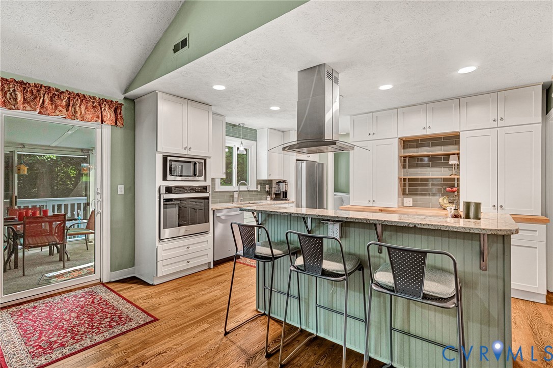 3841 Strawhill Road Richmond, VA 23231 - Photo 13 of 56 Kitchen with wood-finish flooring, white cabinetry