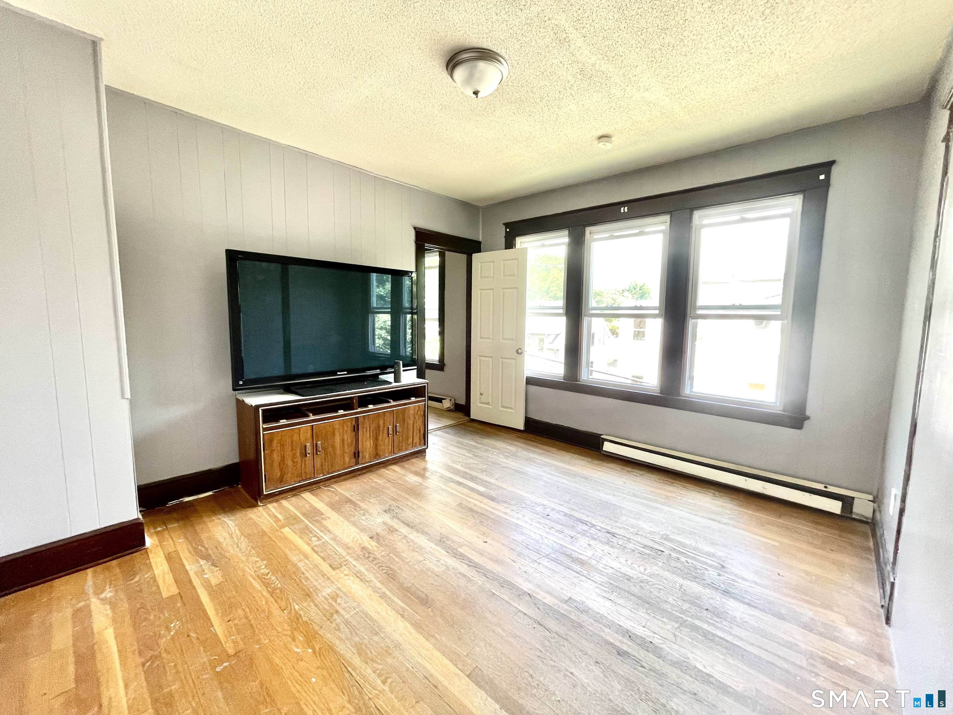 146 Charles Street, Unit 3 Waterbury, CT 06708 - Photo 10 of 20 a living room with a flat screen tv on dresser and a window