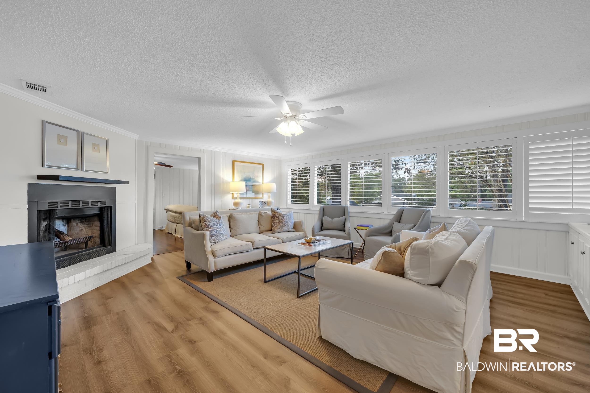 18 York Place Mobile, AL 36608 - Photo 3 of 27 Living area with light wood-style floors, crown molding, ceiling fan, a textured ceiling, and a fireplace