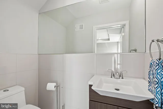 a bathroom with a sink a toilet and a mirror