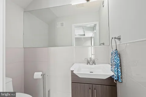 a bathroom with a sink a toilet and a mirror