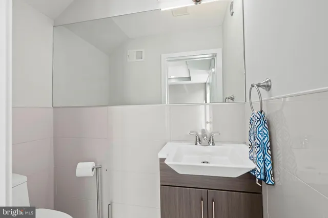 a bathroom with a sink a toilet and a mirror