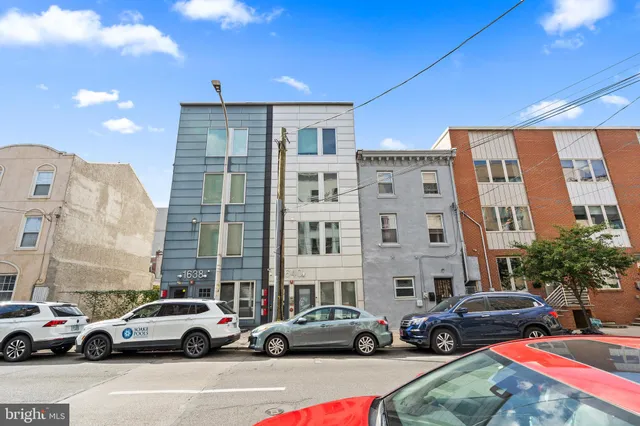 a buildings with car parked in front of it