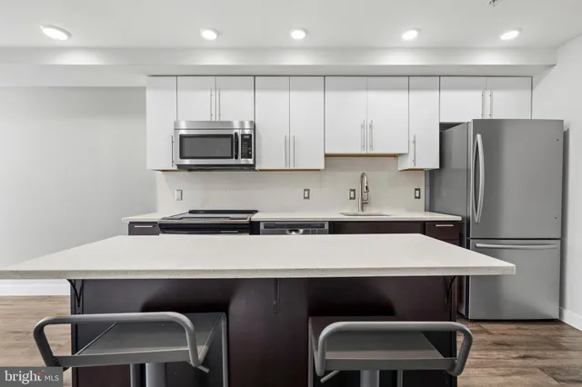 a kitchen with a table chairs refrigerator and microwave