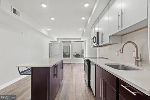 a kitchen with granite countertop a sink and wooden cabinets