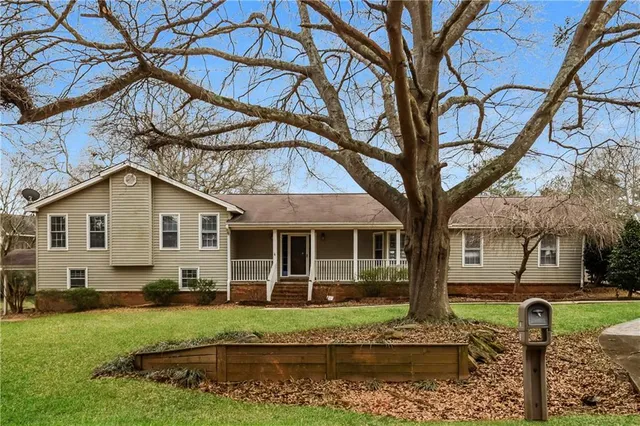 a house view with a garden and large trees