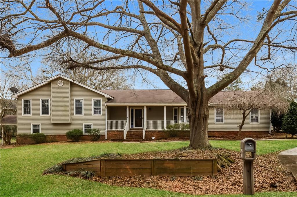 a house view with a garden and large trees