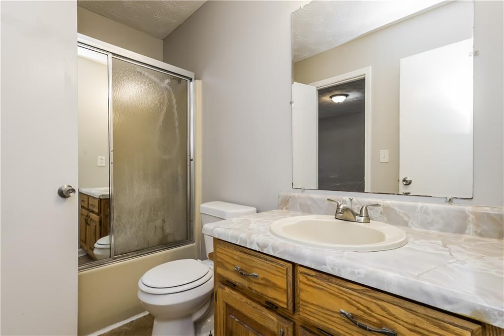 35 Knights Circle Covington, GA 30016 - Photo 18 of 28 a bathroom with a granite countertop sink toilet and shower