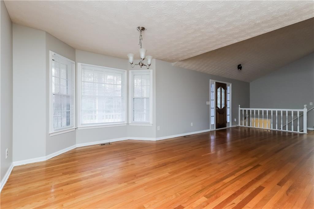 35 Knights Circle Covington, GA 30016 - Photo 20 of 28 a view of an empty room with wooden floor and a window