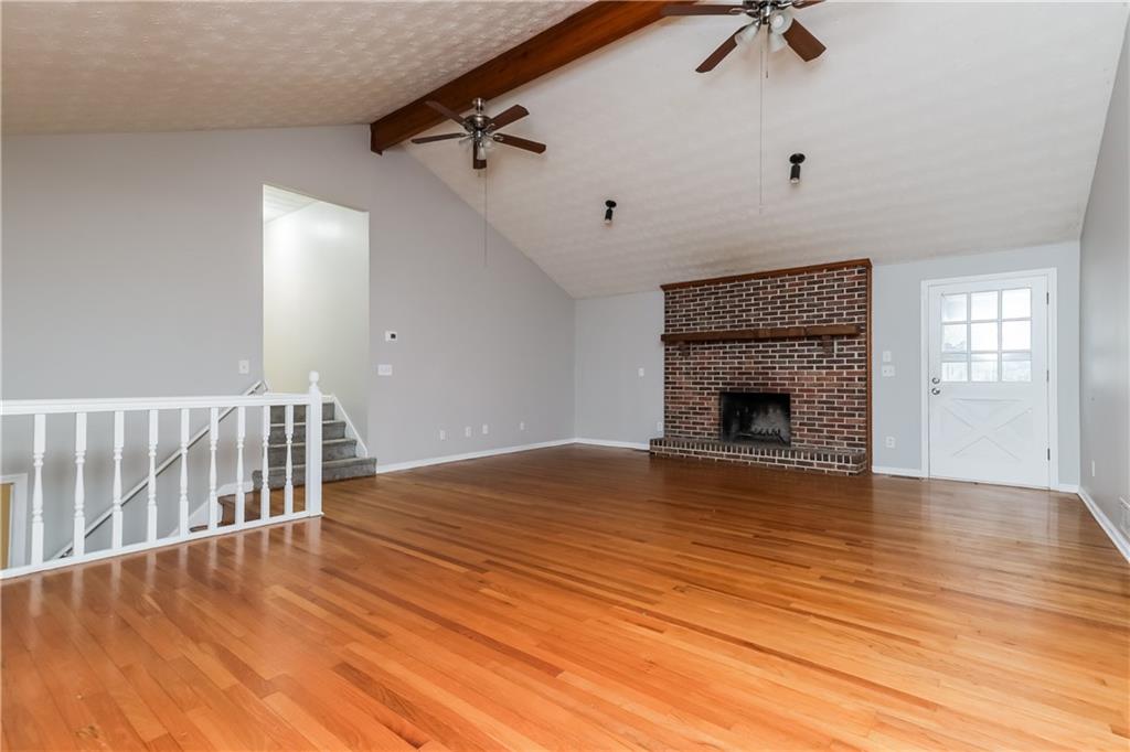 35 Knights Circle Covington, GA 30016 - Photo 2 of 28 a view of empty room with wooden floor and fireplace
