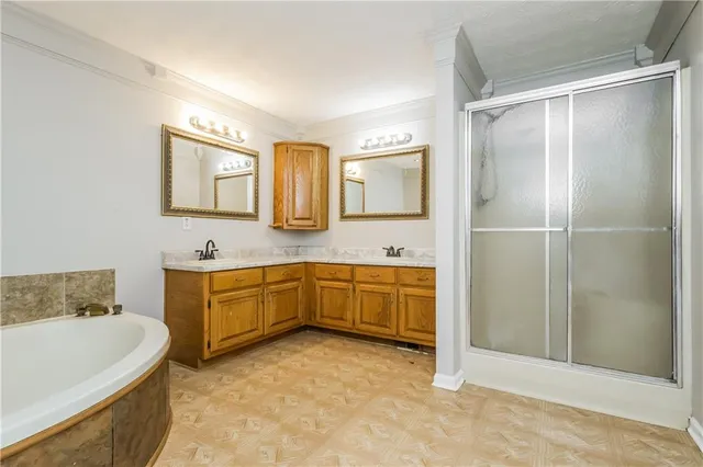 a spacious bathroom with a tub sink and mirror
