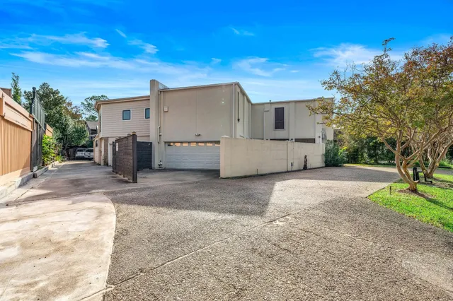 a view of a house with backyard and trees