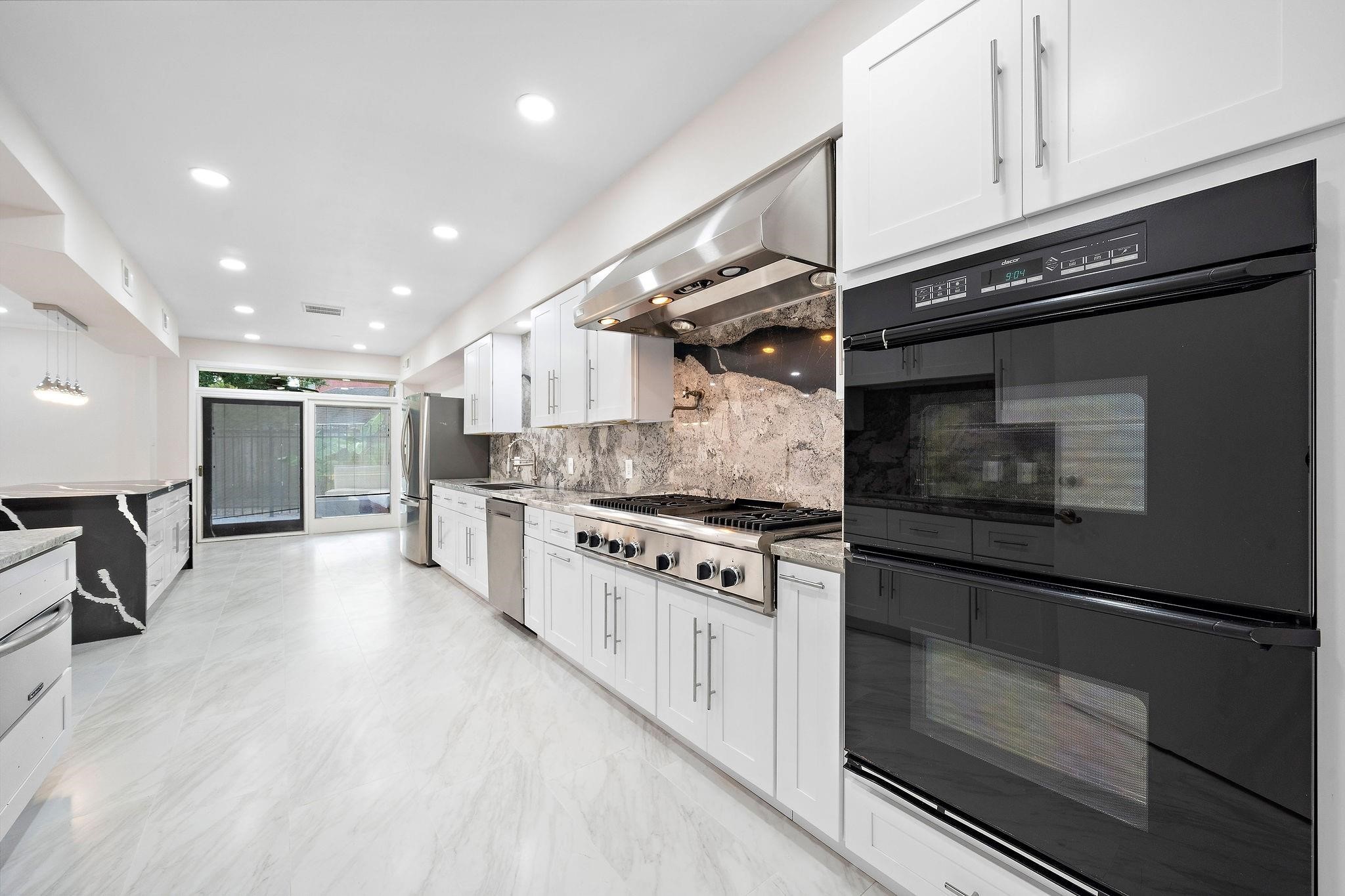 1111 Potomac Drive, Unit B Houston, TX 77057 - Photo 5 of 22 a kitchen with stainless steel appliances granite countertop a stove and a refrigerator