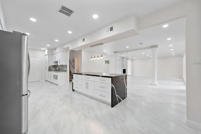 a view of kitchen with kitchen island white cabinets and stainless steel appliances