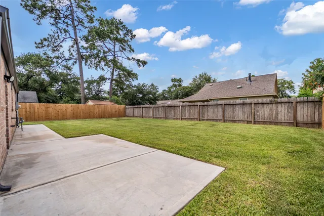 a view of a backyard with grass and a fence