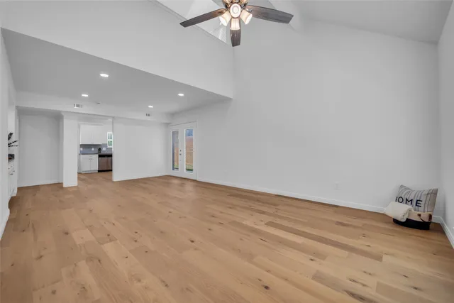 a view of empty room with wooden floor and ceiling fan
