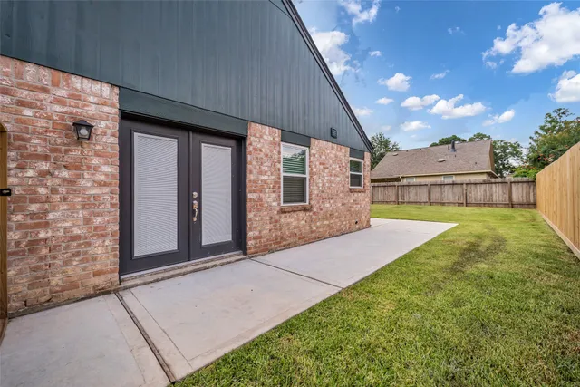 a view of an house with backyard and a patio