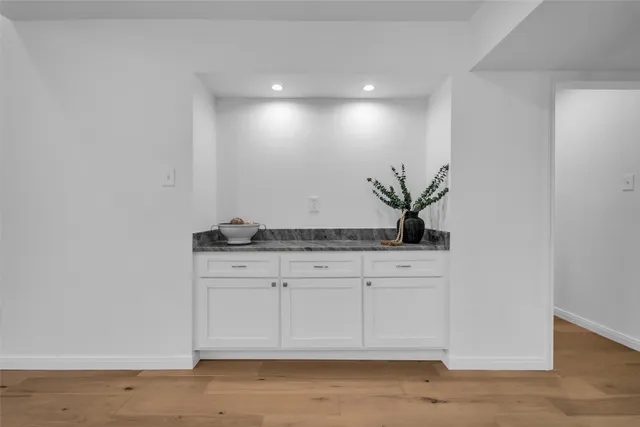 a view of cabinets a wooden floor and a potted plant