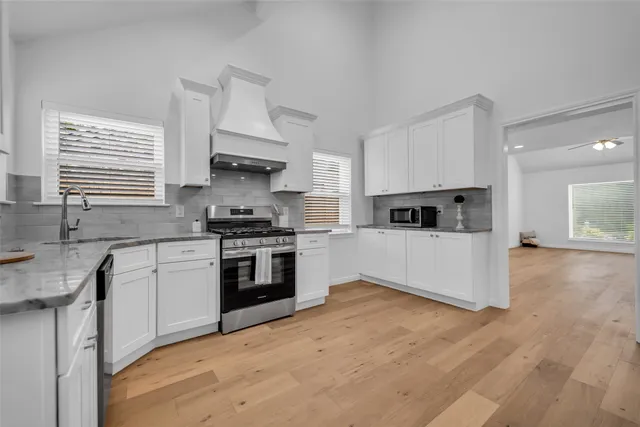 a kitchen with granite countertop a stove top oven and cabinets
