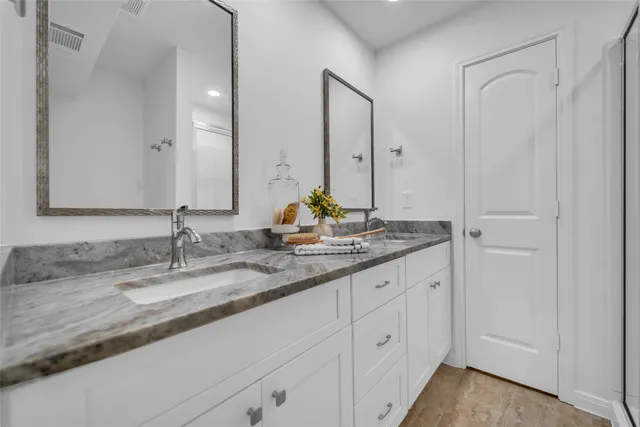 a bathroom with double sink and a mirror