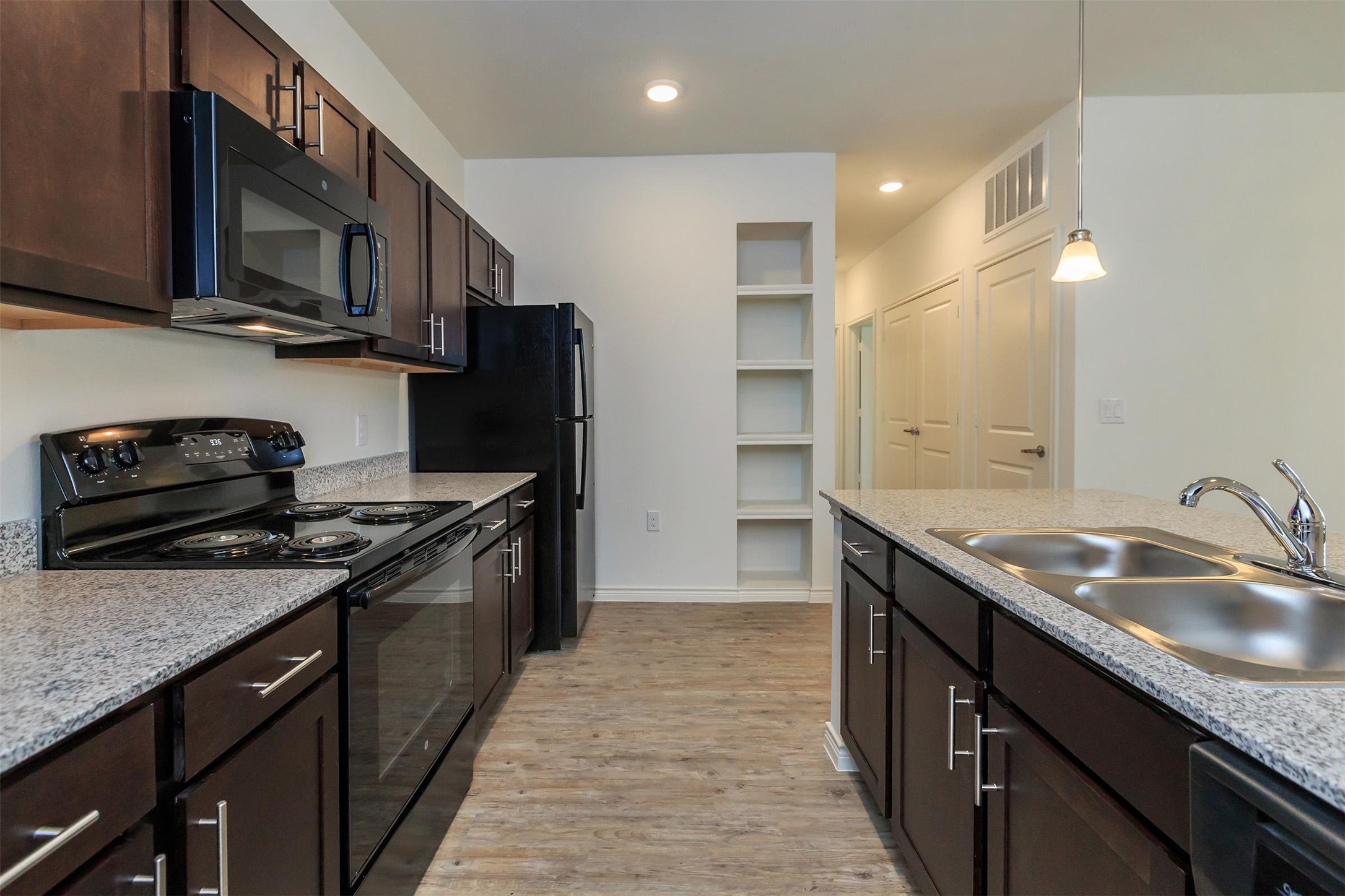 5712 Azle Avenue Fort Worth, TX 76106 - Photo 12 of 15 a kitchen with stainless steel appliances granite countertop a sink stove microwave refrigerator and cabinets