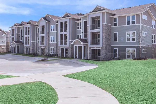 a front view of a residential apartment building with a yard